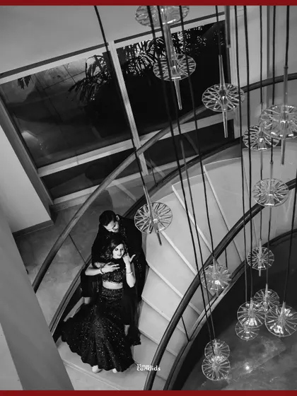 A dramatic, high-angle black and white shot of the couple on a grand staircase. This architectural portrait from their reception feels both modern and timeless.