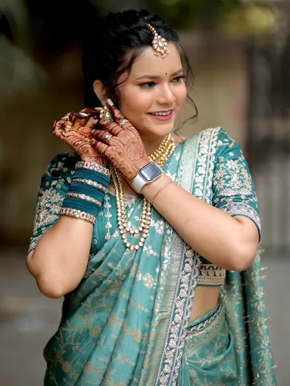 A candid moment of the bride adjusting her earring, giving a lovely view of her mehendi.