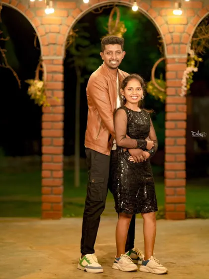 A stylish couple's portrait in a modern setting with brick arches. The casual outfits and confident pose give this a cool, urban vibe.