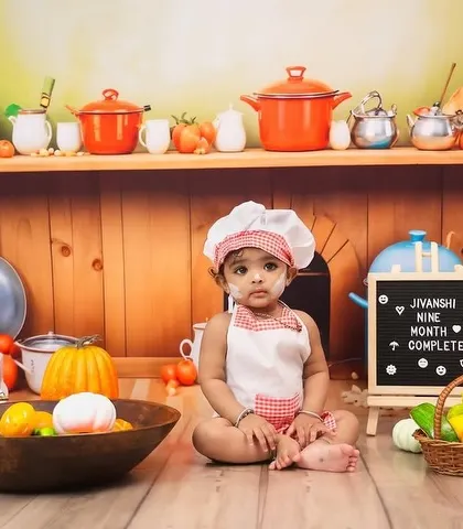 A sweet portrait of the baby with a little flour on her nose in the kitchen setup.