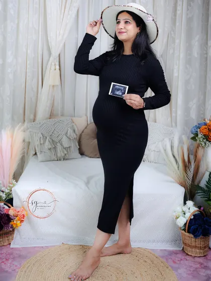 A lovely portrait combining a stylish hat and the first ultrasound picture. This shot is a beautiful blend of fashion and heartfelt emotion.
