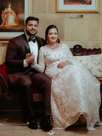 A classic, seated portrait of an engaged couple in a luxurious setting.