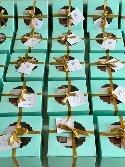 A large order of return favors for a naming ceremony. These sea-green boxes with a window are an elegant way to thank guests.