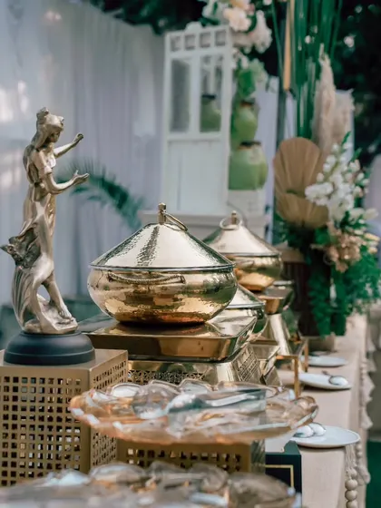 A close-up of the luxurious details on my buffet counter, including hammered golden serving bowls and artistic statuettes that elevate the food display.