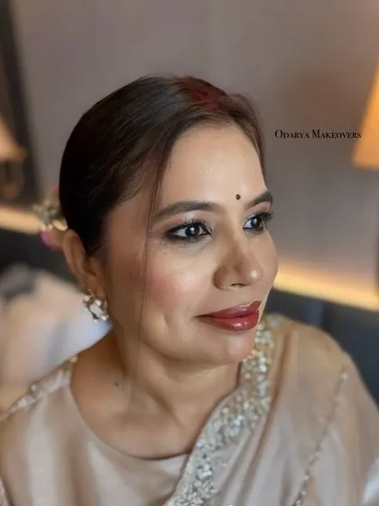 A close-up of her makeup, showing the soft kohl-rimmed eyes and glossy nude lips. A timeless and sophisticated look.