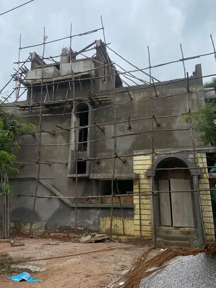 The house in its early construction phase, showing the addition of new floors on top of the original single-story structure. This image documents the beginning of the adaptive reuse process.