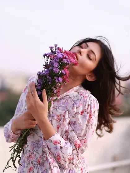 Lost in the beauty of nature. This portrait, with her face buried in a bouquet of wildflowers, is a celebration of sensory joy and peace.