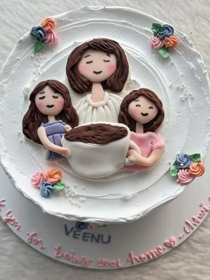 A sweet cake for a mom from her daughters, featuring a handcrafted topper of them sharing a cup of coffee.