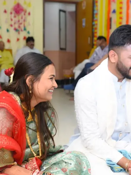 A candid moment of shared laughter during the puja, showing that even solemn ceremonies are filled with lighthearted moments.