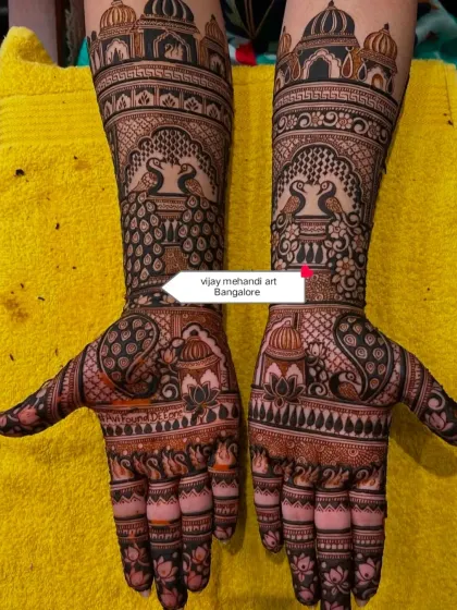 A classic and symmetrical full-hand bridal design. This style features traditional Rajasthani elements like palace architecture, facing peacocks, and lotus flowers, creating a timeless and royal look for your wedding day.