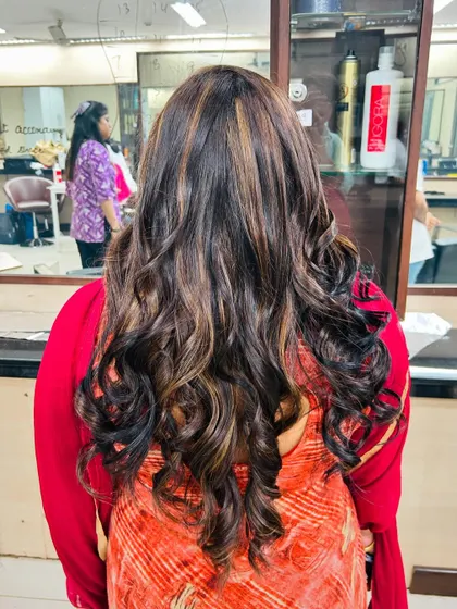 Another angle of the global color with highlights, showing how the light catches the different tones in the hair. Our students learn to place highlights strategically for a natural, sun-kissed effect.