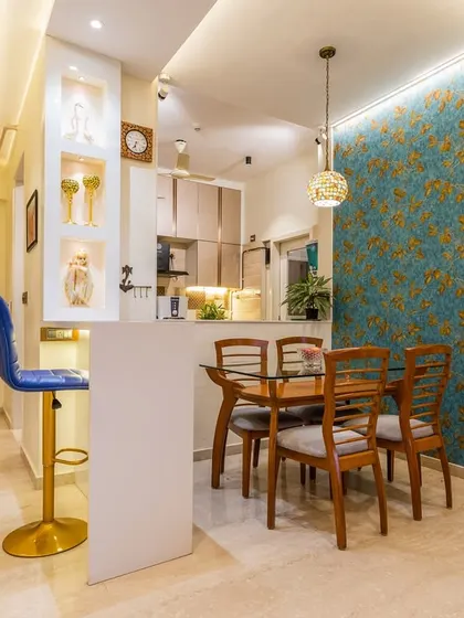 The dining area and breakfast bar feature a bold blue accent wall with a unique wallpaper, adding a pop of color and personality to the space.