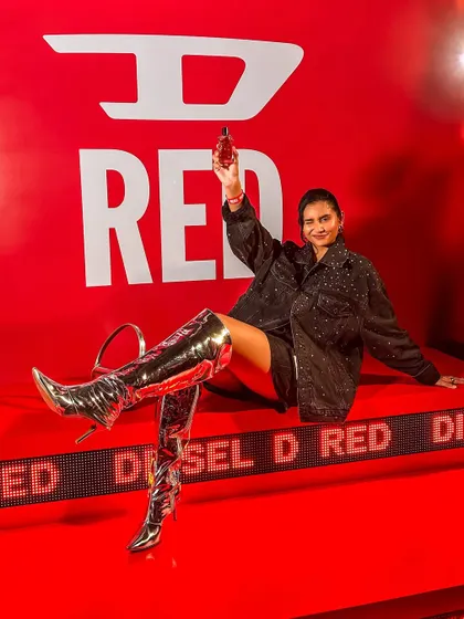 A dramatic pose on a branded installation at the Diesel event, creating a powerful visual for the new D-RED fragrance.