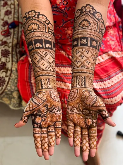 This full-coverage bridal mehendi features symmetrical patterns with traditional elephants and lotuses, balanced with geometric jaal work for a classic yet contemporary look.