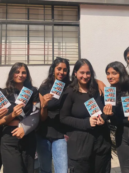 A group of friends, all holding their matching photo strips.