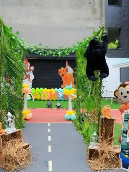 Welcome to the jungle! This grand entrance for a jungle safari theme features a leafy arch, animal cutouts, and rustic props like hay bales to set a wild and adventurous tone.