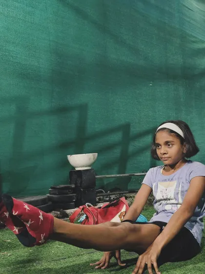 A young girl holding a strong L-sit. Her focus and determination are an inspiration to us all.