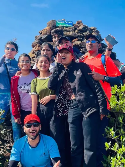 The group celebrating at the Pushpagiri Peak sign on the Kumara Parvatha trek.
