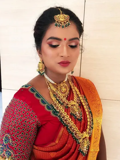 A close-up of the South Indian bride's makeup, focusing on the defined eyes and bold red lip, which beautifully complements her traditional attire.