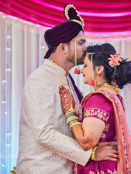 A tender moment of affection. The groom's kiss on the bride's forehead is a classic portrait that radiates love and happiness.