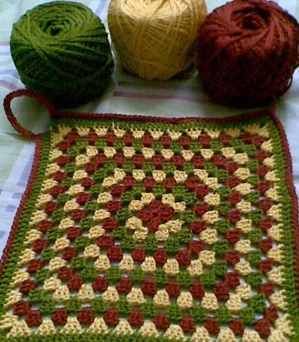 An early granny square project of mine, used as a pot holder. The earthy tones of green, yellow, and maroon are still some of my favorites to work with.