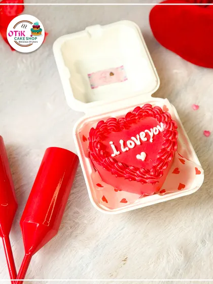A heart-shaped red bento cake, perfect for Valentine's Day. The simple "I Love You" message and intricate piping make it a sweet and romantic gesture.