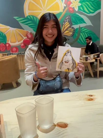 A thumbs up and a big smile. She loved her caricature at The Black Coffee Cafe.