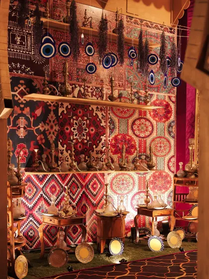 Another view of the artifact market, with hanging evil eye charms, brass hookahs, and patterned textiles creating a rich tapestry of cultural objects.