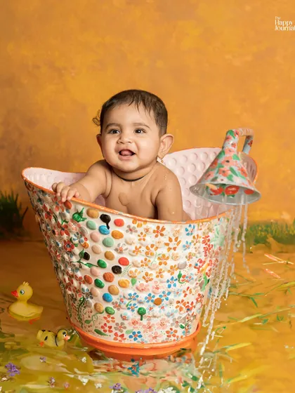 Splish, splash! A baby has a fun bath time in a colorful, mosaic-style tub, complete with rubber ducks and a big, happy smile.