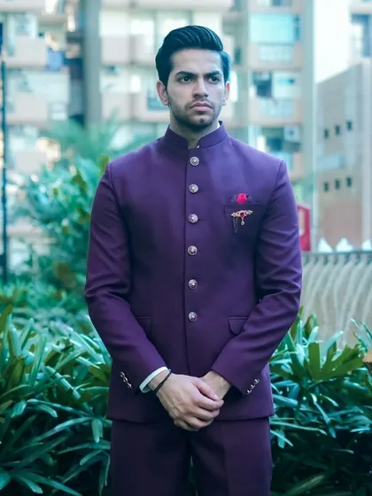 A close-up of the deep purple Jodhpuri suit, showing the fine fabric and the detailed buttons.