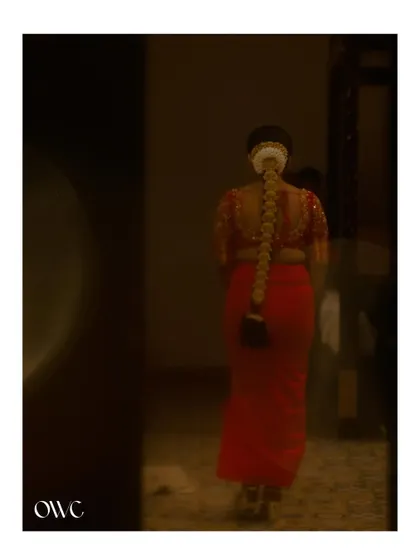A moody and mysterious shot of the bride from behind, walking into a dark room.