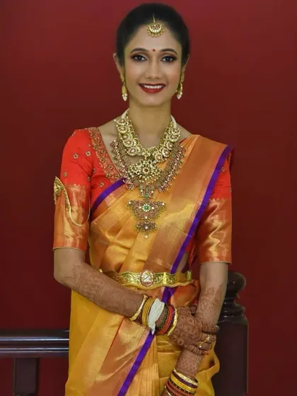 This bride is glowing in her yellow and orange Kanjeevaram. I created a classic look with a defined eye and a warm lip color to match the vibrancy of her saree.