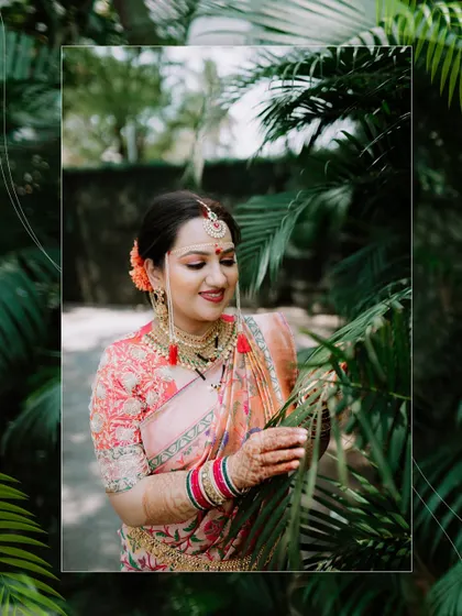 A lovely portrait of the bride posing amidst lush green foliage, creating a beautiful contrast with her attire.