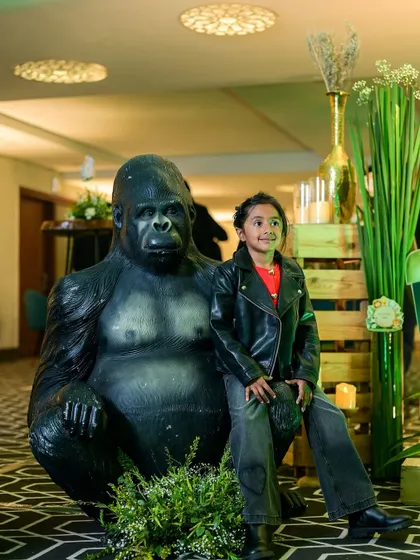 Even the youngest guests get to be part of the theme. Here, a little one poses with a life-sized gorilla prop at our jungle-themed first birthday party.