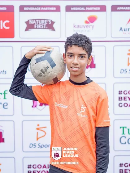 A young footballer proudly holds a ball for a photo. I ensure every participant gets their moment in the spotlight with professional event photography.