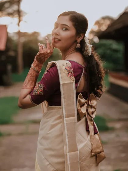 A beautiful over-the-shoulder shot of the bride, showing the elegant bow detail on her blouse.