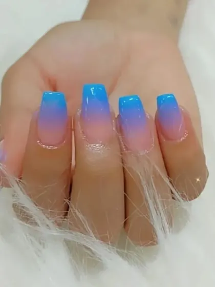 A vibrant blue-to-purple ombré on clear extensions, creating a beautiful "jelly" nail effect.