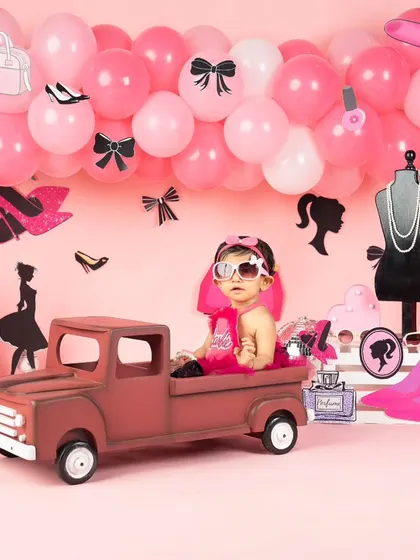 A cool pose with sunglasses in her pink truck. This little girl has so much personality.