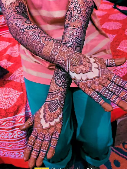 A beautiful pose showing off the rich stain of this architectural-style mehndi on the back of the hands.
