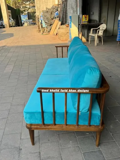 Side profile of the teak wood spindle-back sofa.