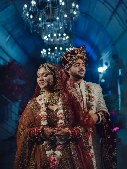 A stunning portrait of the couple under a grand chandelier.