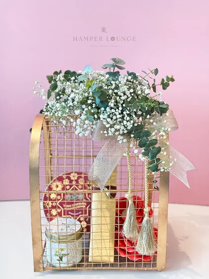 This tall, bird-cage-style metal hamper is a unique packaging option for Eid. Filled with treats and topped with a beautiful arrangement of baby's breath, it’s a gift that is both elegant and whimsical.