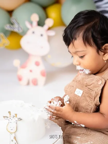 A close-up of the cake investigation. I focus on these small details, the tiny hands exploring the texture of the frosting, which tells a bigger story of their first birthday experience.