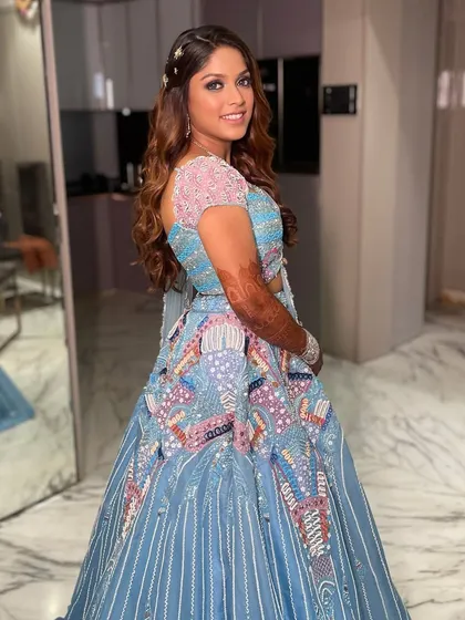Unveiling a vibrant carnival sangeet look! The makeup features a pop of color and a flawless base to match the fun and festive energy of her beautiful blue and pink lehenga.