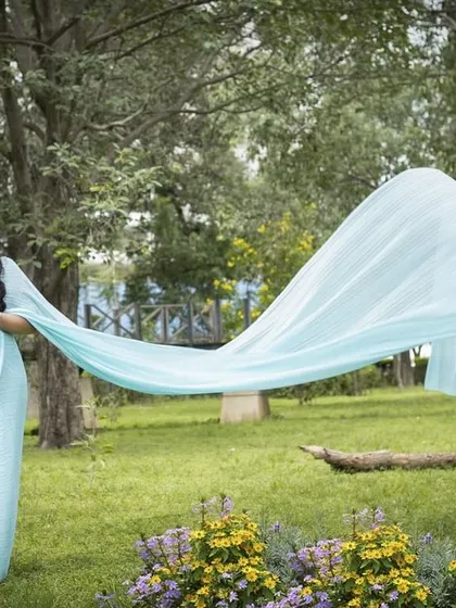 A beautiful maternity portrait in a light blue long-trail saree. This is a wonderful way to have an elegant and traditional look for your outdoor photoshoot.