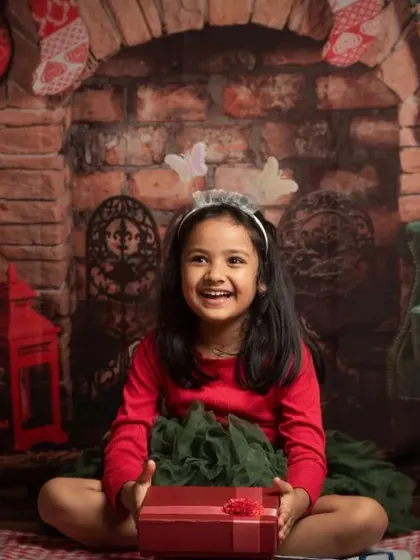 A collection of happy kids enjoying my two distinct Christmas setups: a bright, snowy winter scene and a warm, rustic brick fireplace.