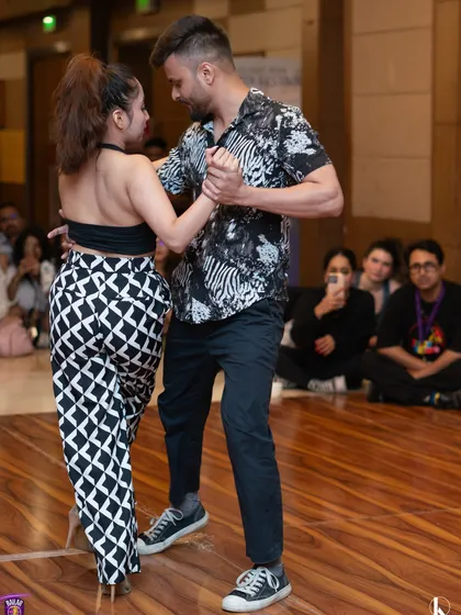 This image captures the intricate footwork and partner connection of Riya and Ravi's Kizomba routine. We focus on musicality and precision in our performance coaching.
