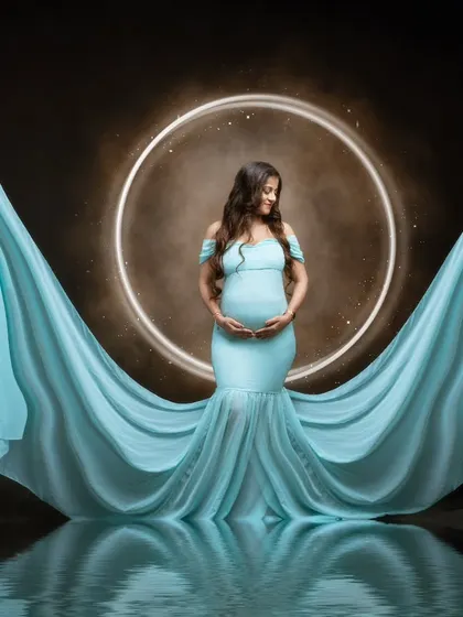 Reflections of love. This serene portrait shows our mumma-to-be in a flowing sea-blue gown, her peaceful demeanor reflected in the calm waters below.