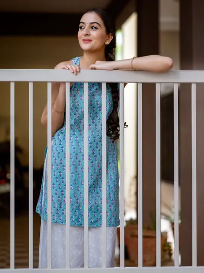 A portrait framed by the vertical lines of the gate. The composition is interesting and the mood is peaceful.