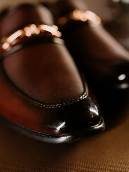 A close-up, detailed shot of the groom's polished leather shoes.
